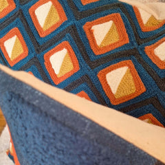 Adama Embroidered Cushion with colorful geometric pattern showcasing detailed stitching and vibrant textures.