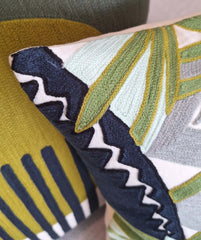 Alba Embroidered Cushion showcasing vibrant embroidery details on soft fabric in various colors and patterns.