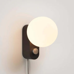 Alumina Lamp Charcoal with a matte-porcelain sphere-shaped shade and a charcoal black base, featuring a dimmable LED bulb, by Tala