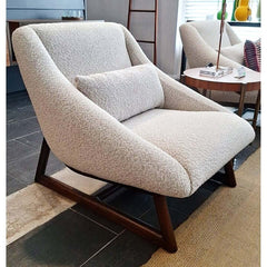 An armless chair with a solid wood base in a dark finish and beige fabric upholstery.