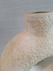 Close-up of a textured ceramic Artemis Vase against a gray background