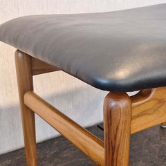 Close up of a Teak Chief Stool Black Leather seat 