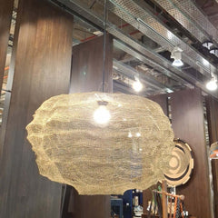 Handwoven pendant light made of copper wire mesh in gold finish