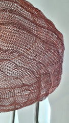 close up of handwoven pendant light made of copper wire mesh in copper finish