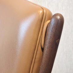 Close-up of a Cynthia Armchair Tan Leather with wooden backrest.