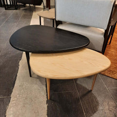 Two triangular-shaped coffee tables, one with a dark stained top and dark legs, and the other with a light stained top and light legs