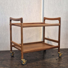 Teak bar cart with two shelves on wheels and handles on both sides