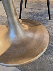 close up of oval-shaped Eclipse Dining Table antique brass finish base 