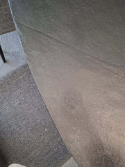 close up of oval-shaped aluminium Eclipse Dining Table top with blackish bronze finish top