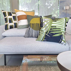 Embroidered Cushion styled with vibrant pillows on a modern sofa, showcasing artistic designs and textures.