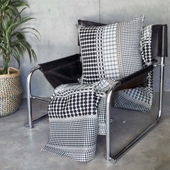 Margo Selby Etch Square Cushion on a leather armchair