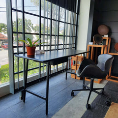 A black PU office chair with metal frame, equipped with wheels and adjustable height mechanism