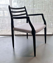 A black solid ash wood frame dining chair with a light grey upholstered seat and backrest.