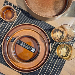 A round, brown stoneware Form Art dinnerware with a matte finish and a visible brown glaze, by ASA selection