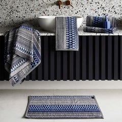 A bathroom display of blue grey patterned towels, includes hand towels, bath towels and Kensal Bath Sheet by Margo Selby