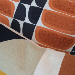 Kivi Embroidered Cushion featuring vibrant patterns and textures in warm tones, perfect for adding style to your home decor.