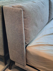 Upholstered king bed with metal legs and grey fabric, pictured without a footboard