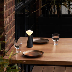 A portable lamp with a granite black base and LED bulb, by Tala