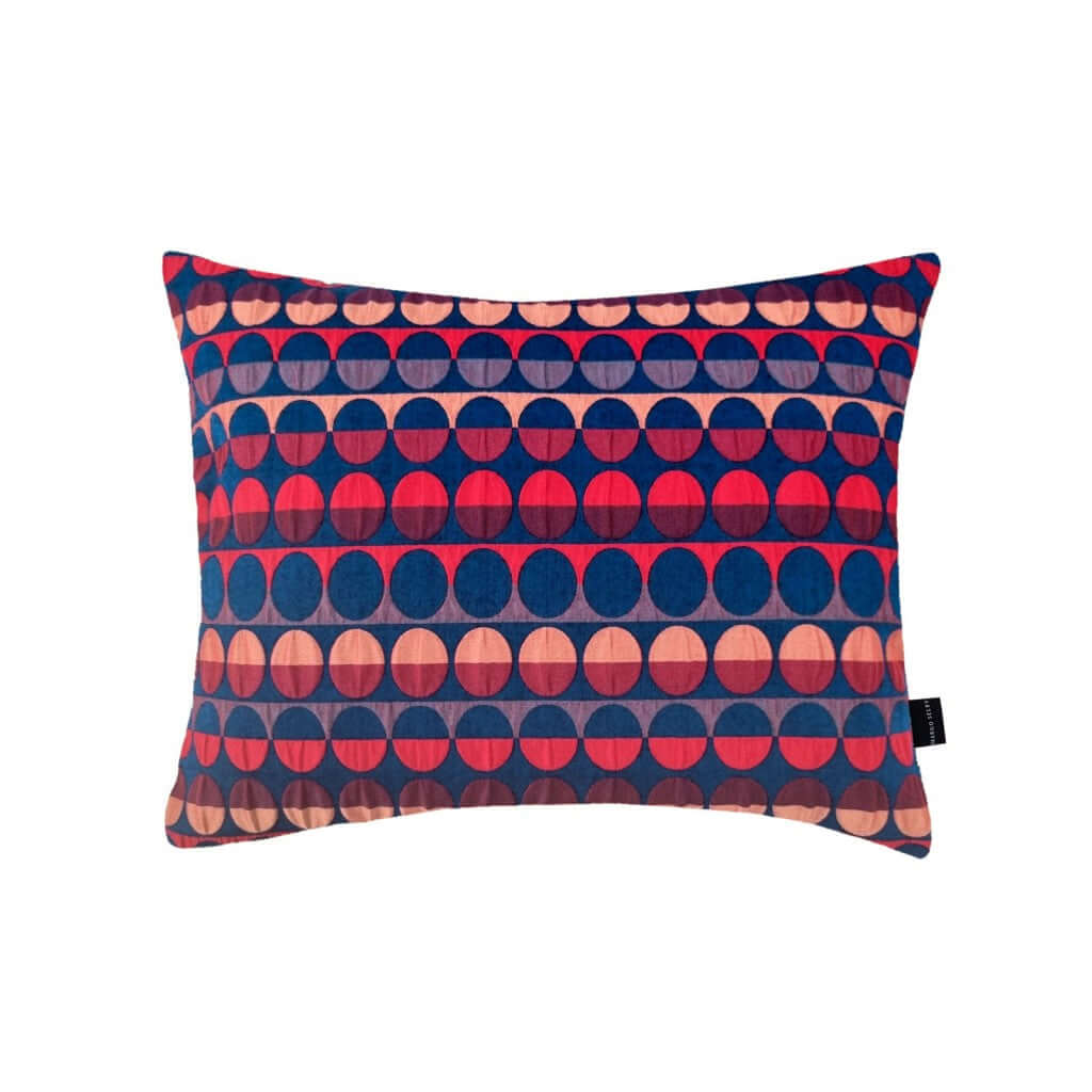 Millie Rectangle Cushion with a geometric pattern of red and blue circles and semicircles, by Margo Selby