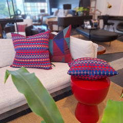 Margo Selby Millie cushions on  a sofa and a red stool