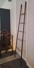 A seven feet tall solid walnut wood ladder with five rungs, designed to stand against a wall for hanging towels or clothes.