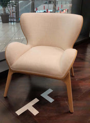 An armchair with a light wood base and off-white fabric upholstery.