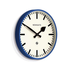 Newgate Railway Wall Clock Blue with a blue silicone case and a white dial. The clock hands are black, and the design includes bold markers and a glass lens.