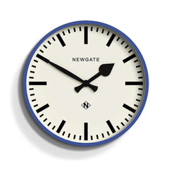 Newgate Railway Wall Clock Blue with a blue silicone case and a white dial. The clock hands are black, and the design includes bold markers and a glass lens.