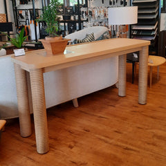 A rectangular wooden console table with four round legs featuring a grooves pattern.