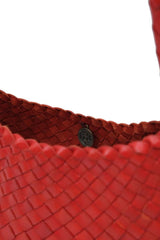 Close-up of a Dragon Diffusion Rosanna Poppy Red woven leather handbag with a visible medallion