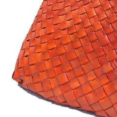 Close Up of Dragon Diffusion Santa Croce Big Orange with asymmetric leather straps and a woven basket-like design.