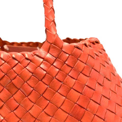 Close Up of Dragon Diffusion Santa Croce Big Orange with asymmetric leather straps and a woven basket-like design.
