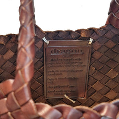 Close Up of Dragon Diffusion Santa Croce Small Bruciato with asymmetric leather straps and a woven basket-like design.