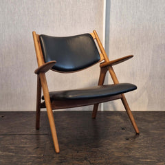 Sawbuck Lounge Chair Black Leather seat and backrest in teak natural finish