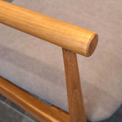 Close-up of teak armrest on Seven Armchair Cotton Canvas in dark taupe cushioned seat and backrest 