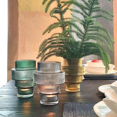 A collection of Steps Candle Holder Amber with vertical ridges, featuring an intricate and textured design, by Pols Potten