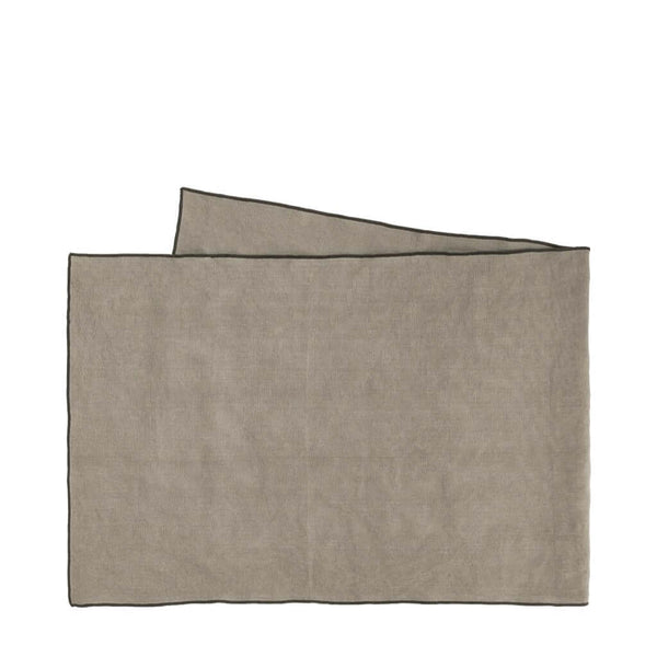 A beige linen table runner with a black cordon stitch edge, by ASA selection