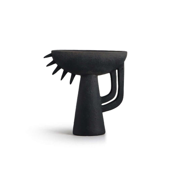 A black ceramic vase with an abstract and geometric shape
