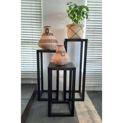 pedestal made of solid ash wood with an open pore finish in charcoal color, designed to display vases, plants, or sculptures.