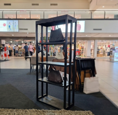 A solid timber display Tipis Tall Bookshelf with four open sections, stained in charcoal color.