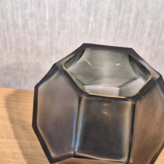 Tundra Tealight Holder 9cm in cool silver-grey frosted glass, its geometric facets casting a soft, fractured glow when lit from within.