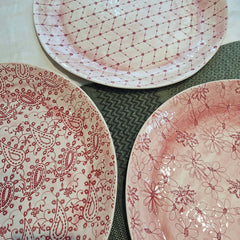 Three ceramic cake plates with red floral and paisley patterns