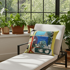 Picasso Cushion - Les Colombes (1957) with a vibrant abstract design featuring elements such as birds, trees, and geometric shapes on a yellow background, with a visible Picasso-style painting inspiration.