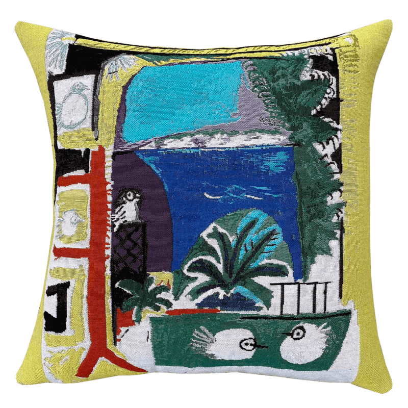 Picasso Cushion - Les Colombes (1957) with a vibrant abstract design featuring elements such as birds, trees, and geometric shapes on a yellow background, with a visible Picasso-style painting inspiration.