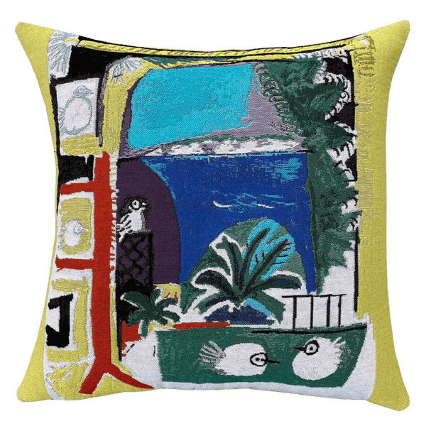 Picasso Cushion - Les Colombes (1957) with a vibrant abstract design featuring elements such as birds, trees, and geometric shapes on a yellow background, with a visible Picasso-style painting inspiration.