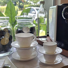 A Table Coffee Cup With Saucer and A Table Espresso Cup With Saucer with a hand-painted black line design around the edge, by ASA selection