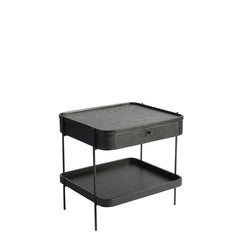 A two-tier side table with a drawer, featuring a black powder coated metal frame and a gray oak veneer tabletop with solid oak edging.