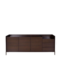 A dark brown Mora Sideboard with three doors on the left side and three drawers on the right side, made of smoked eucalyptus veneer on mdf with a glass top and stainless steel base.