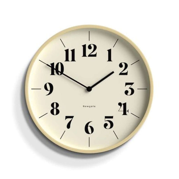 A Newgate Mr Clarke Wall Clock Pale Wood Hopscotch Dial with a pale plywood case and a numerical hopscotch dial with metal hands and a glass lens, displaying the time.