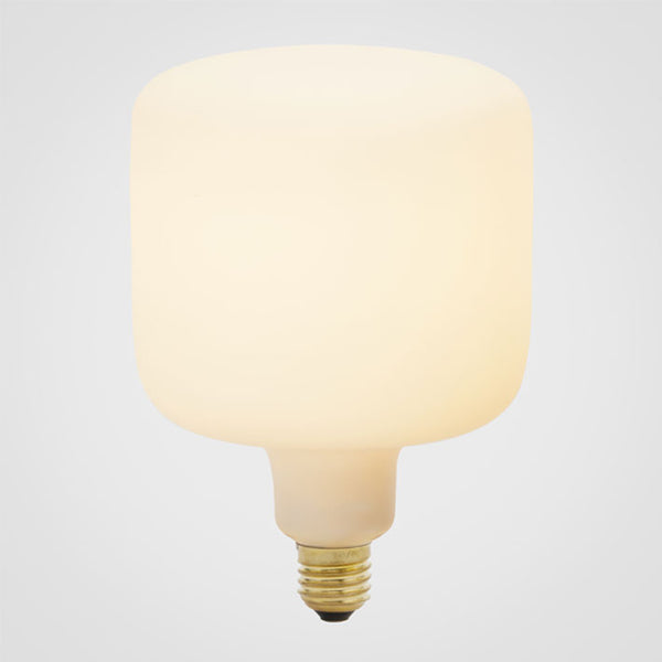 An oblong-shaped LED bulb with a matte glass finish, emitting a soft white light, designed to screw into an Edison-style base, by Tala